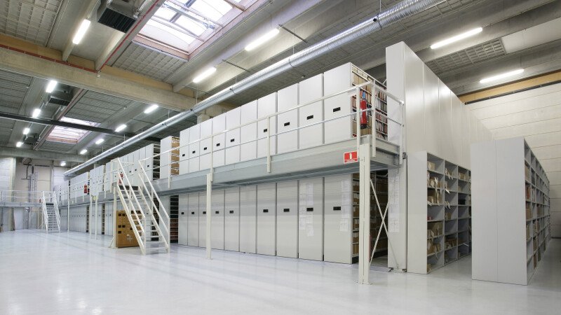 High-density mobile shelving on two floors, maximizing space and storage capacity.